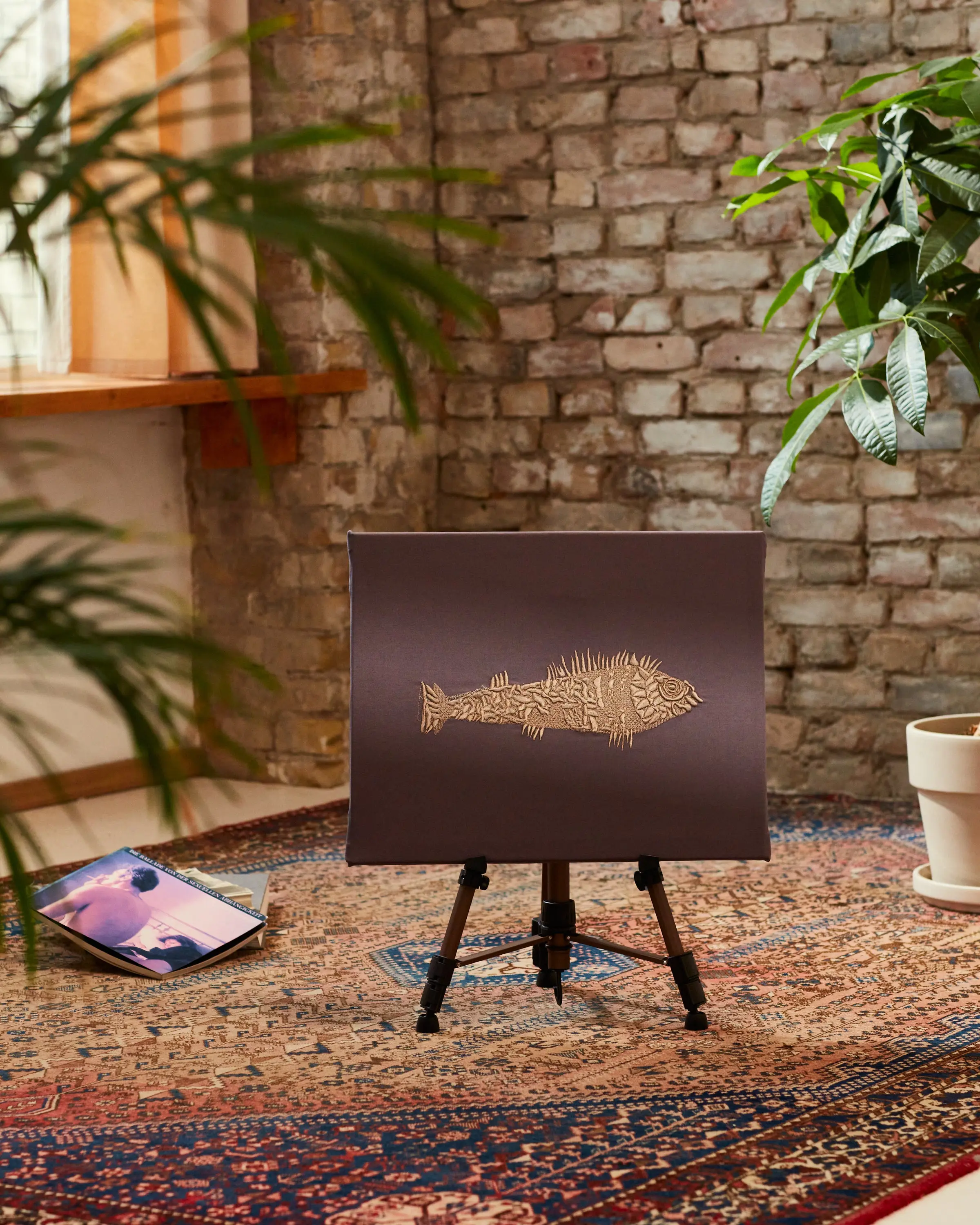 Goldener Fisch auf grauem Stoff