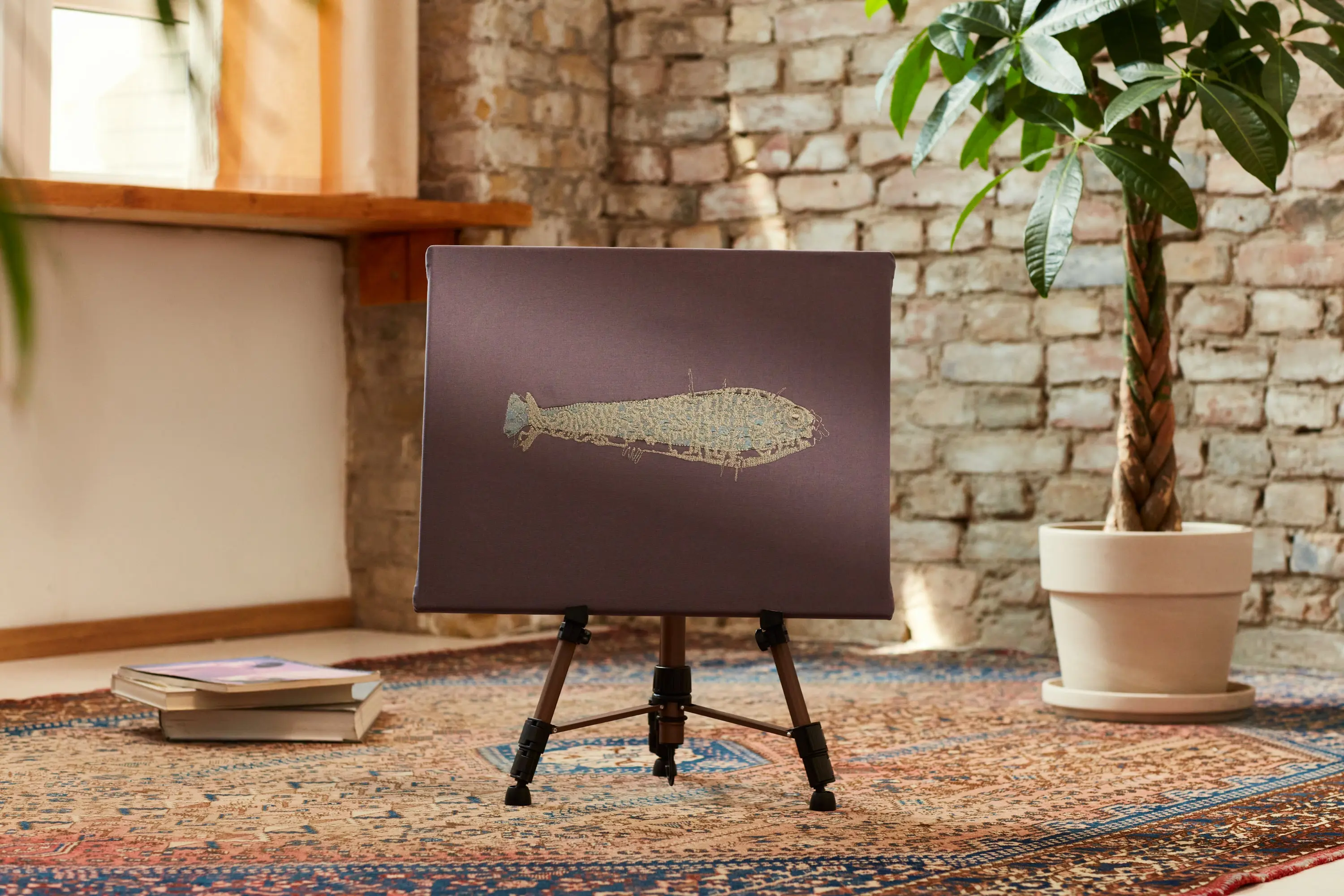 Goldener Fisch auf grauem Stoff