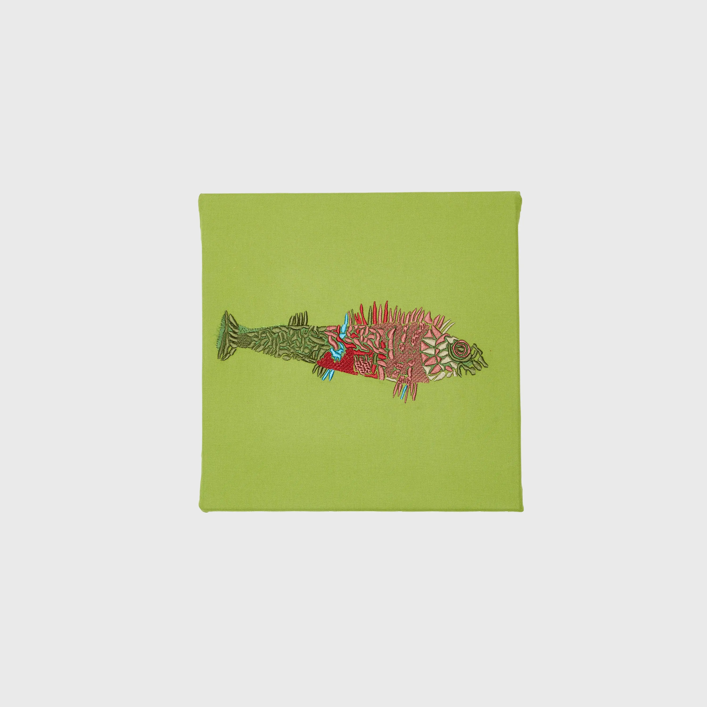 Bunter Fisch in Grün, Blau, Rot und Rosa auf grünem Stoff